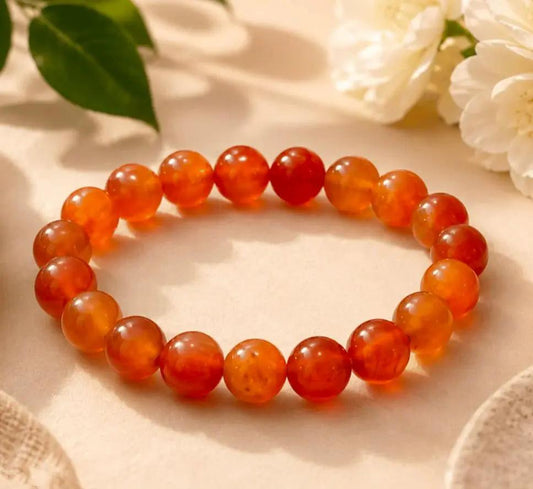 Red carnelian beaded bracelet with smooth polished stones on a neutral background