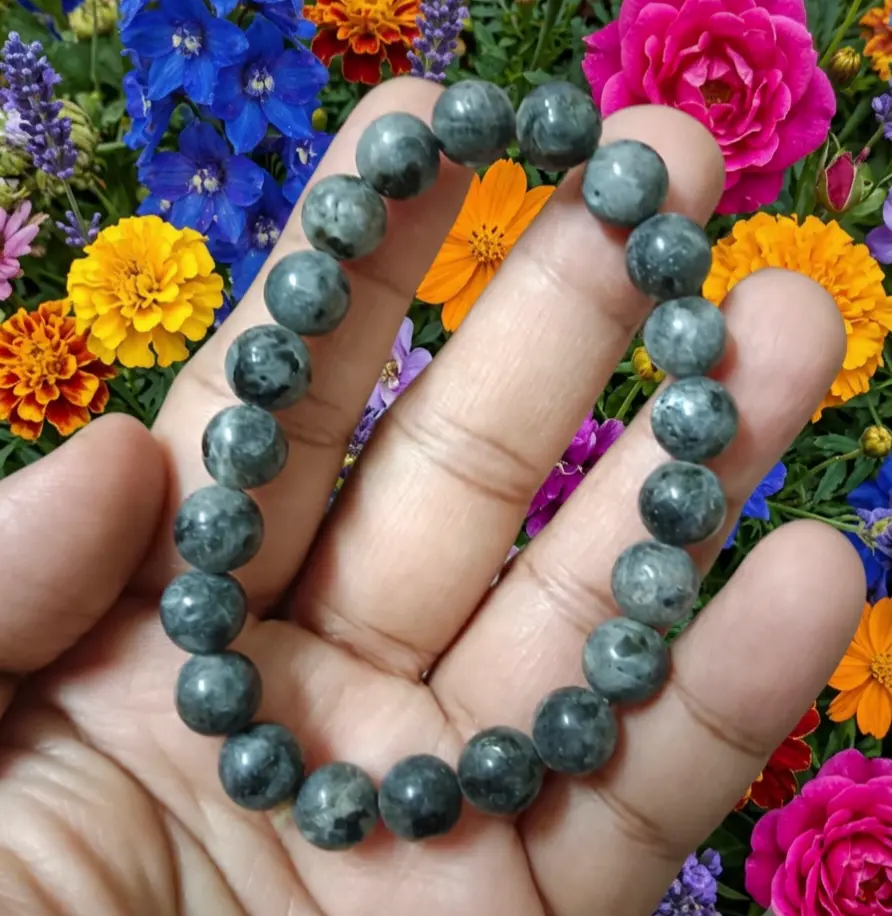 Larvikite bracelet featuring polished blue beads arranged on a plain surface for daily wear
