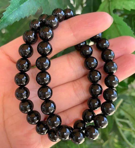 AAA grade black tourmaline beaded bracelet worn on wrist for daily energy protection and grounding.