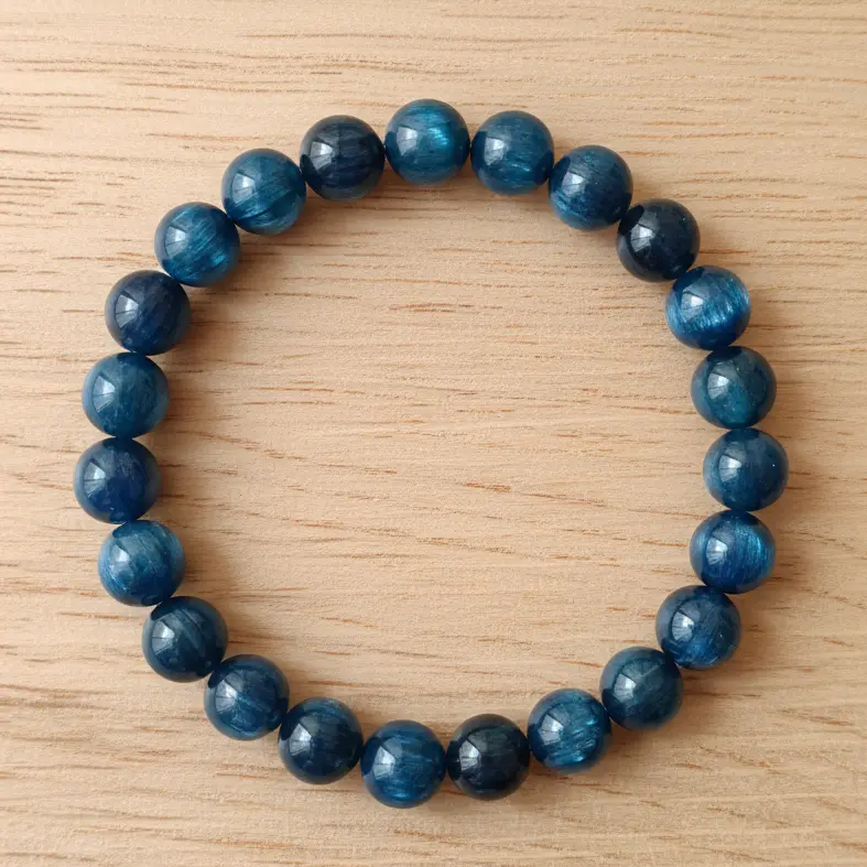 Blackish blue kyanite beaded bracelet resting on a neutral surface for jewelry display.