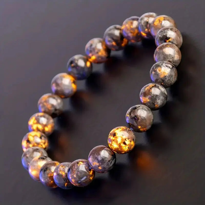 Polished yooperlite bracelet with natural stone beads displayed on a clean neutral background.