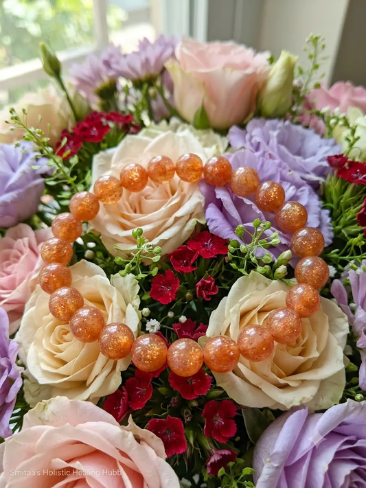 Natural sunstone crystal bracelet with polished round beads displayed on a neutral surface.