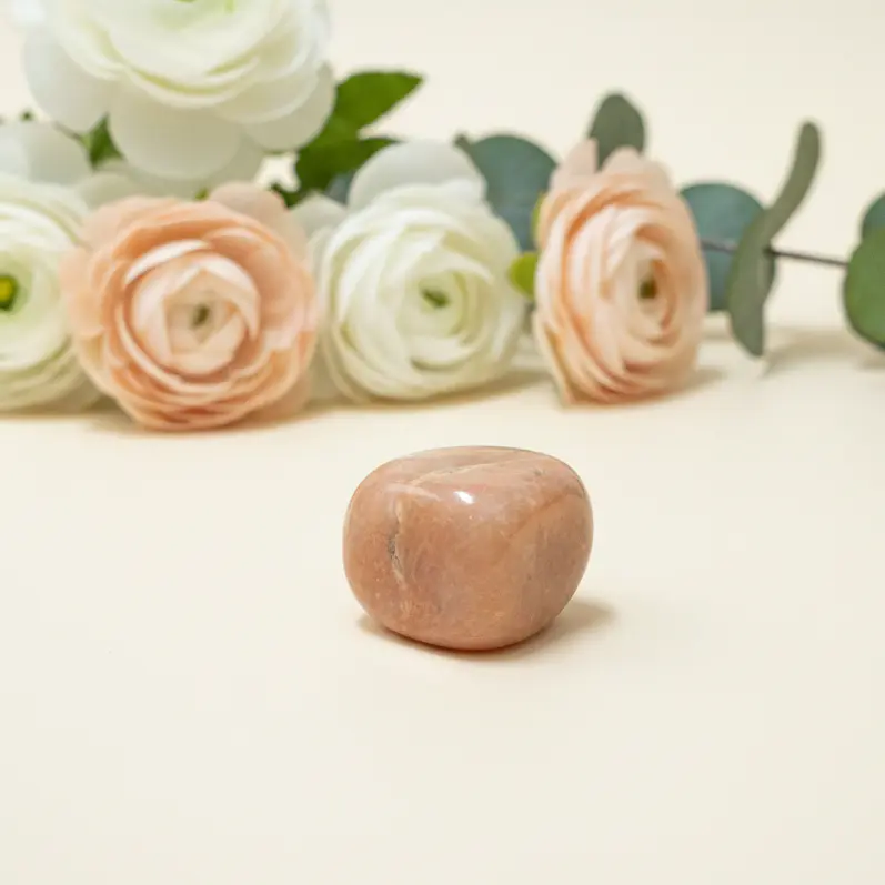 Smooth tumbled peach moonstone crystal with natural peach tones for meditation and home decor.