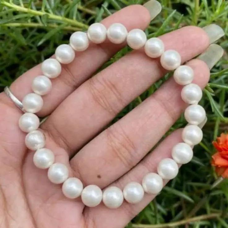 Freshwater pearl bracelet displayed on a soft surface showing natural luster and simple metal clasp