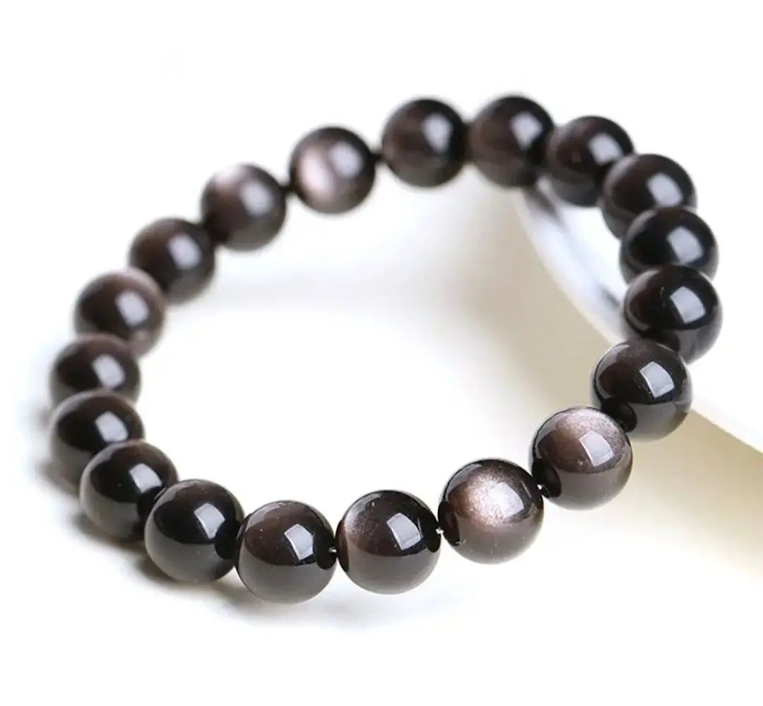 Rare silver obsidian beaded bracelet displayed on a neutral surface for spiritual grounding and daily wear.