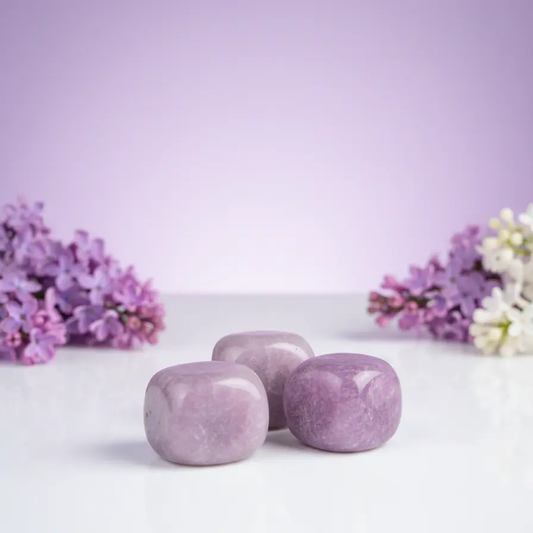 Polished lepidolite tumbled stone displaying natural purple and pink mineral layers for meditation and display