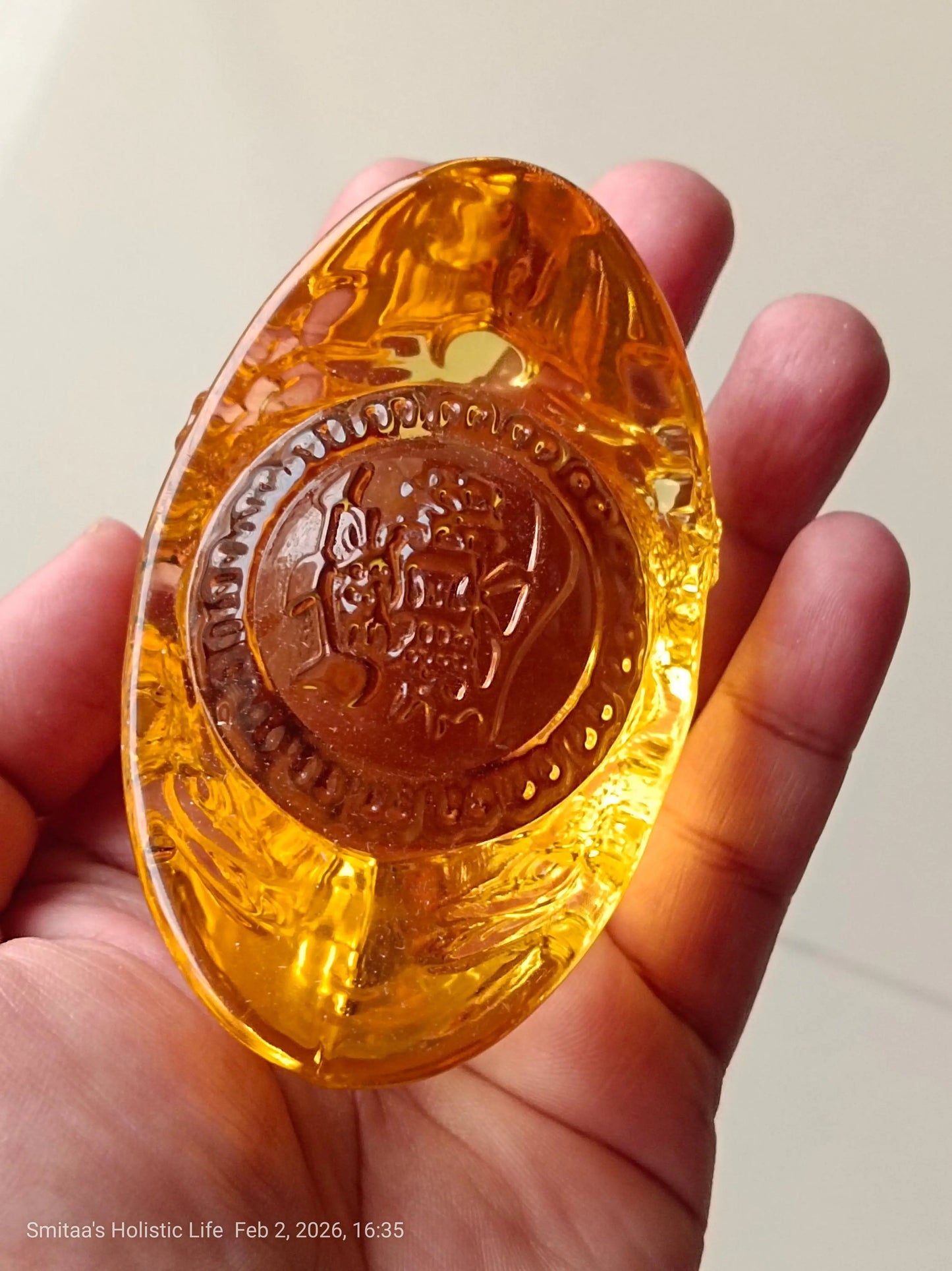 Gold ingot wealth and prosperity ornament displayed on a plain background for home altar decoration.