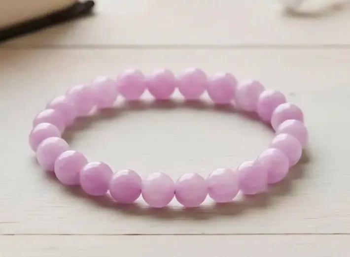 Pink kunzite crystal bracelet worn on a wrist for daily emotional healing and spiritual wellness.