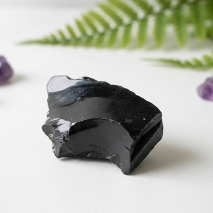 Rough black obsidian stone specimen with natural unpolished surface for grounding meditation practice